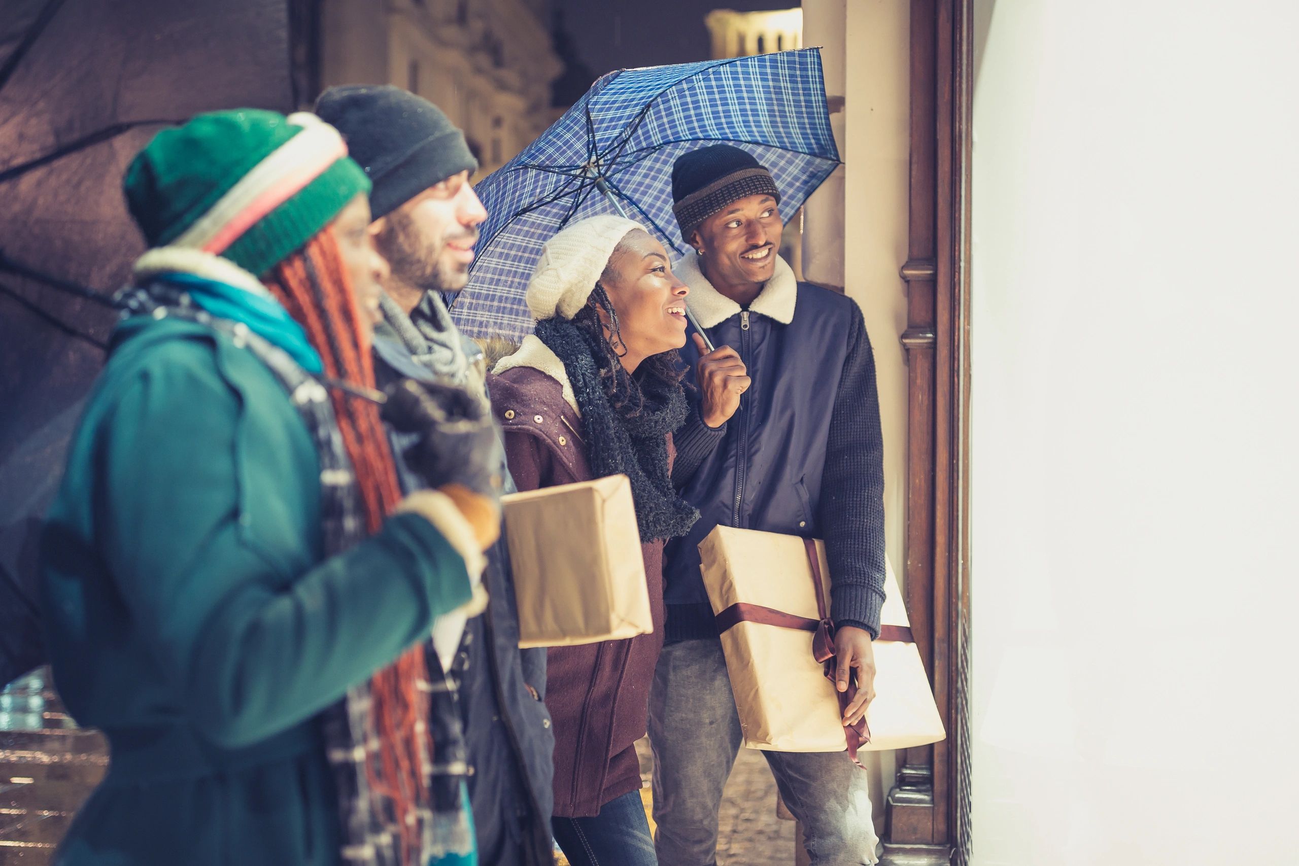 Young shoppers holding gifts outdoors