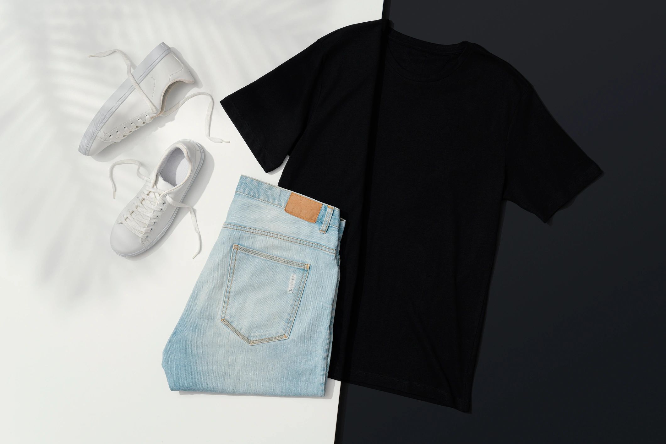 Black t-shirt, jeans, and sneakers flat lay