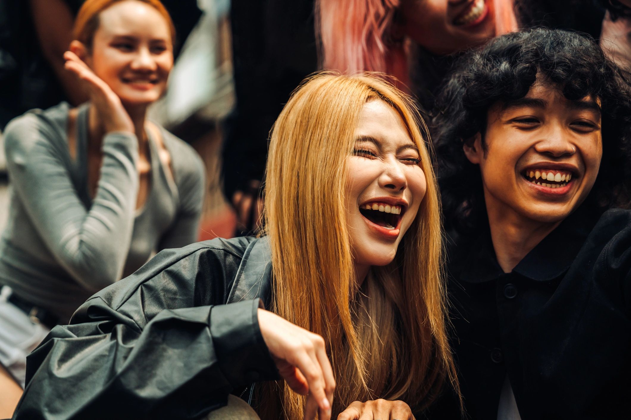 Friends smiling and waving while posing for a selfie