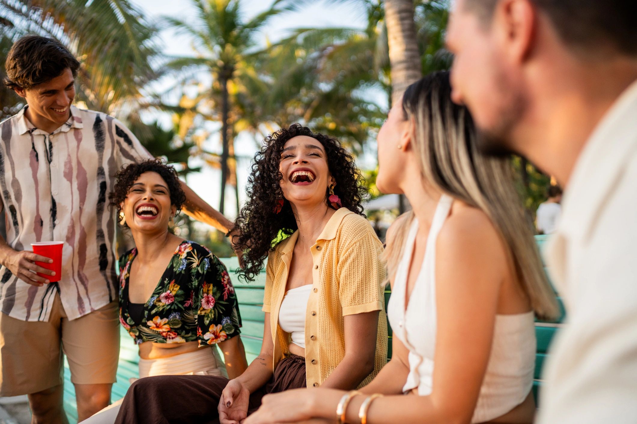 Happy friends talking outdoors in casual streetwear