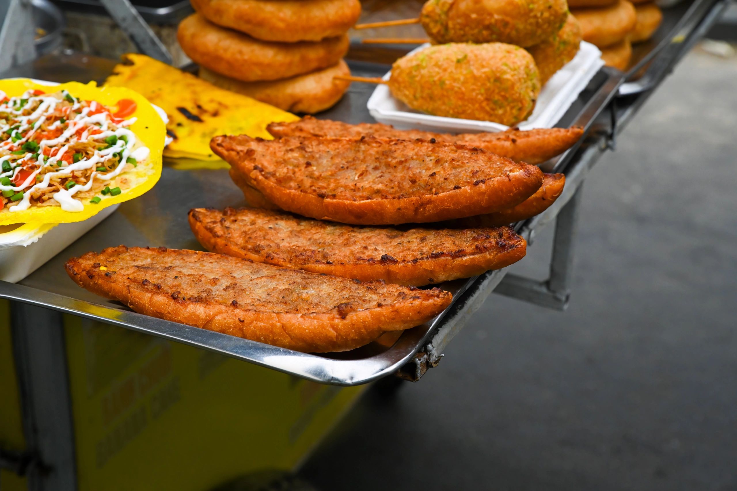 Rows of loaded sandwiches displayed at a lively food stall